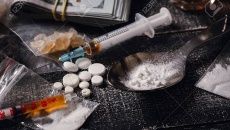 Hard drugs on dark table. Drug syringe and cooked heroin